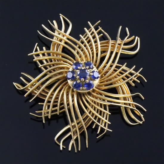 A mid 20th century 18ct gold and sapphire set stylised flowerhead brooch, retailed by Regner of Paris, gross 16 grams.